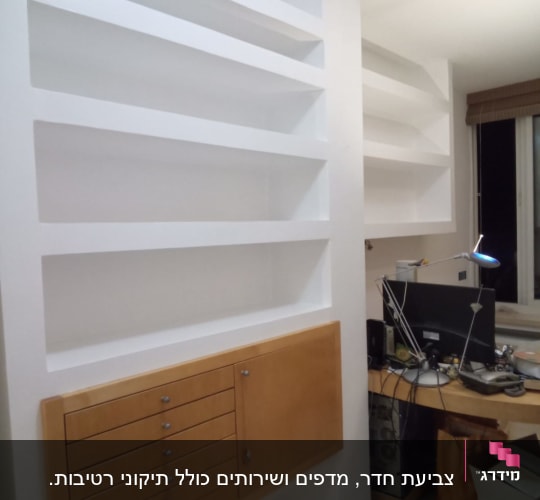 מדפים לבנים צבועים על קיר עם ארון עץ